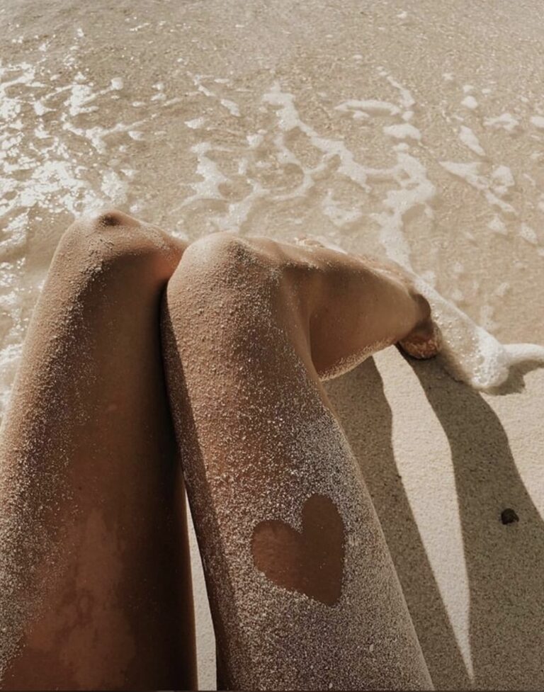 A woman's legs carving a heart in the sand symbolizing empowered divorce solutions and harmonious co-parenting guidance.